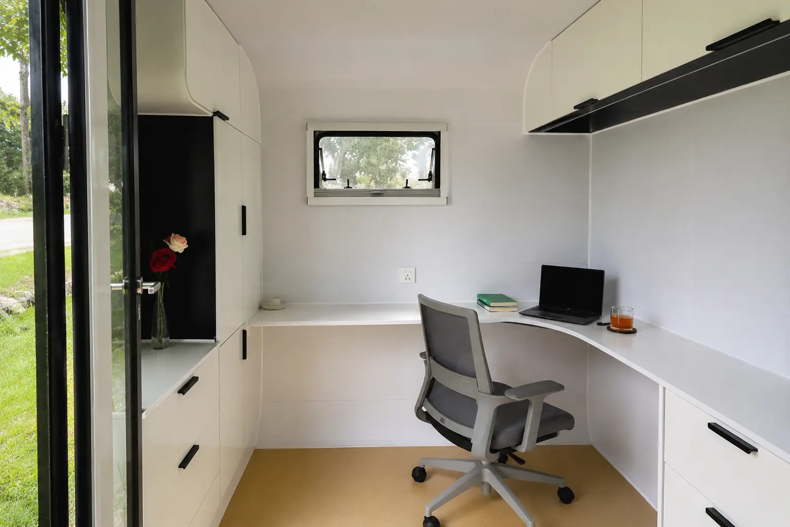 A corner desk beneath a push-out window, finished in warm white joinery